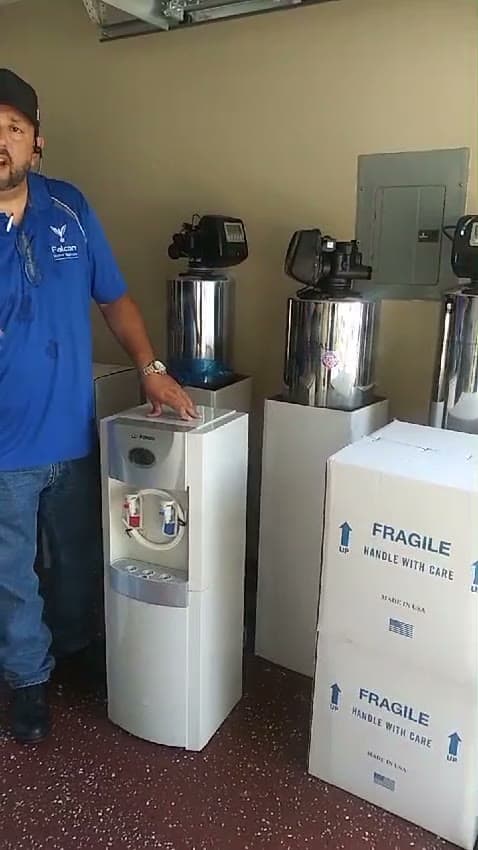 Falcon team member next to water coolers and stainless tanks ready for delivery