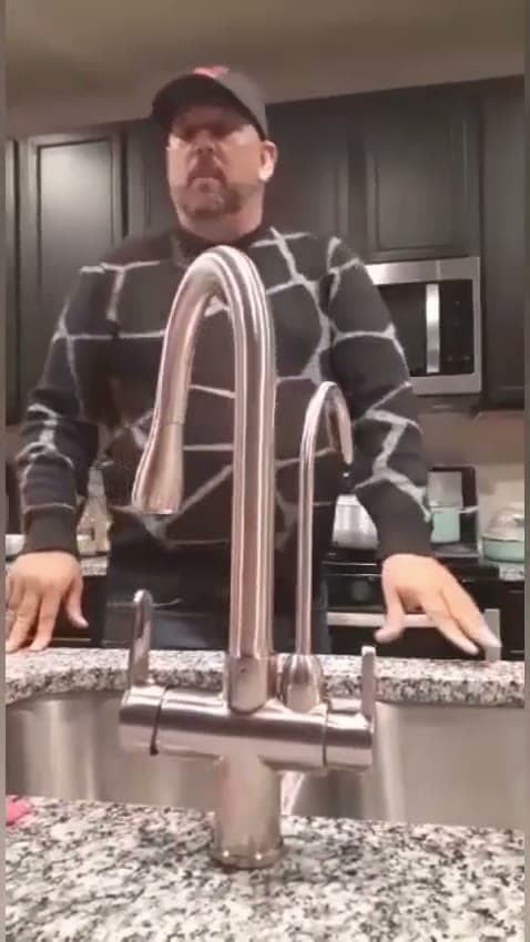 Three way reverse osmosis drinking water faucet running at a kitchen sink
